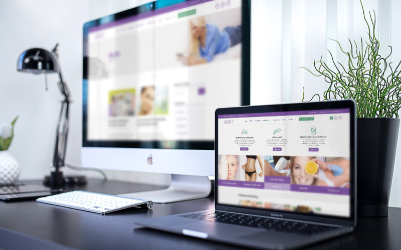 Site para clínica de estética: na imagem tem uma mesa com um monitor de computador desfocado no qual o site da Clínica Zaffy e ao lado há um notebook também com o site da Clínica Zaafy aberto. Ao fundo, desfocados, há uma planta e uma luminária.