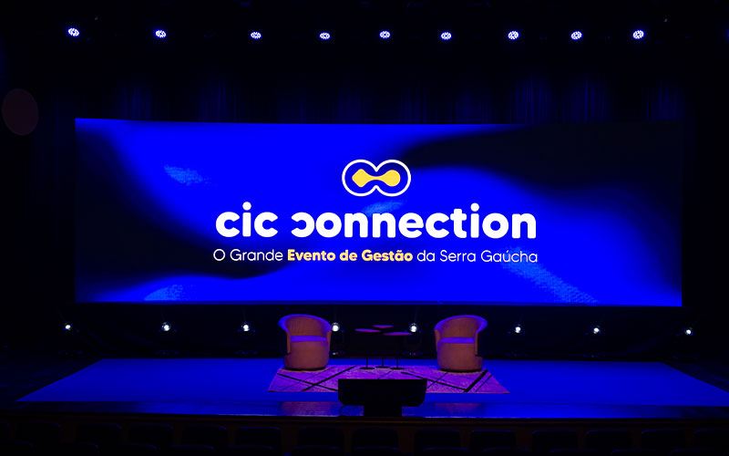 Telão com o logo do evento CIC Connection. É possível ver, também, a tagline “O Grande Evento de Gestão da Serra Gaúcha”.