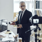 Líder de empresa apresentando gráfico diante da câmera, seguindo estratégia de CEO Content desenvolvida pela Upplay.